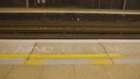 Mind-The-Gap-Warning-On-Edge-Of-Empty-Platform-At-Railway-Station-In-Early-Morning