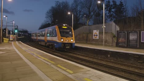 Early-Morning-Shot-Of-Commuter-Train-Arriving-At-Platform-Of-Railway-Station-At-In-Bushey-UK