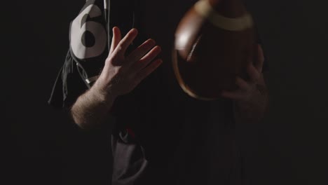 Close-Up-Studio-Shot-Of-American-Football-Player-Holding-Ball-With-Low-Key-Lighting-2