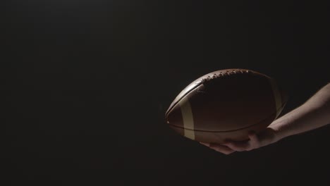Close-Up-Studio-Shot-Of-American-Football-Player-Holding-Ball-With-Low-Key-Lighting-5