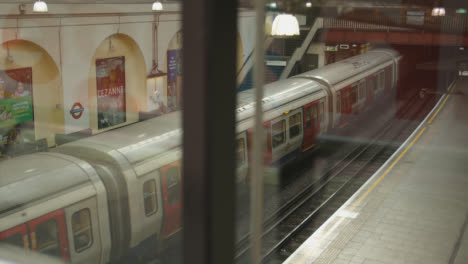 Tube-Tren-Dejando-La-Plataforma-En-La-Estación-De-Metro-De-Fulham-Broadway-En-Londres,-Reino-Unido