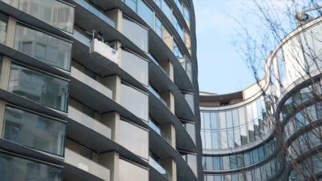 Workmen-In-Inspection-Cradle-Outside-Luxury-Housing-Apartments-At-Battersea-Power-Station-Development-In-London-UK-1