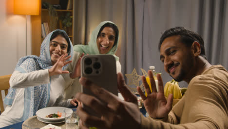 Muslimische-Familie-Macht-Videoanrufe,-Sitzt-Zu-Hause-Am-Tisch-Und-Isst-Iftar-Mahlzeit-Und-Bricht-Während-Des-Ramadan-Täglich-Das-Fasten