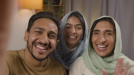 POV-Aufnahme-Einer-Muslimischen-Familie,-Die-Zu-Hause-Am-Tisch-Sitzt-Und-Einen-Videoanruf-Tätigt