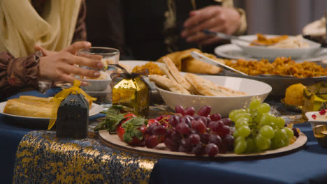 Nahaufnahme-Einer-Muslimischen-Familie,-Die-Am-Tisch-Sitzt-Und-Essen-Zum-Essen-Serviert,-Um-Eid-Zu-Feiern