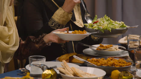 Nahaufnahme-Einer-Muslimischen-Familie,-Die-Am-Tisch-Sitzt-Und-Eid-speisen-Feiert,-Die-Serviert-Werden-1