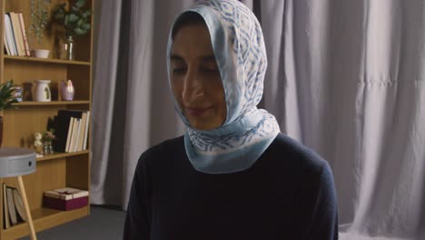 Muslimische-Frau-Trägt-Hijab-Zu-Hause,-Kniet-Und-Betet