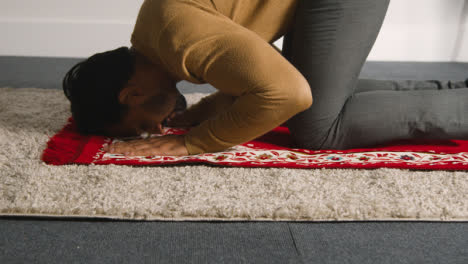 Muslim-Man-At-Home-Kneeling-On-Prayer-Mat-And-Praying-1