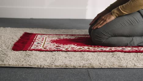 Muslimischer-Mann-Zu-Hause-Kniet-Auf-Gebetsmatte-Und-Betet-1