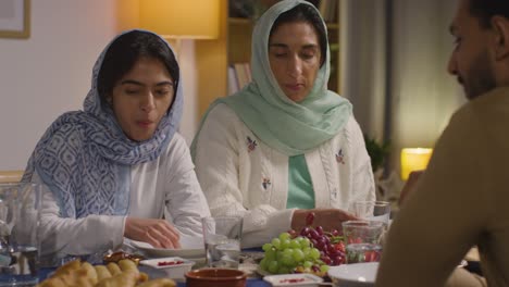 Muslimische-Familie-Sitzt-Zu-Hause-Am-Tisch-Und-Isst-Gemeinsam