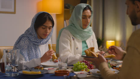 Muslimische-Familie-Sitzt-Zu-Hause-Am-Tisch-Und-Isst-Gemeinsam-1