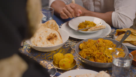 Nahaufnahme-Einer-Muslimischen-Familie,-Die-Zu-Hause-Am-Tisch-Sitzt-Und-Eine-Mahlzeit-Isst,-Um-Eid-1-Zu-Feiern