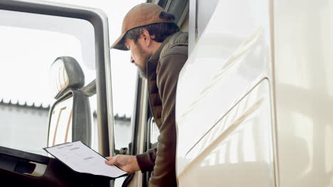 Worker-Wearing-Vest-And-Cap-Organizing-A-Truck-Fleet-In-A-Logistics-Park-While-Reading-Documents-In-A-Truck-2