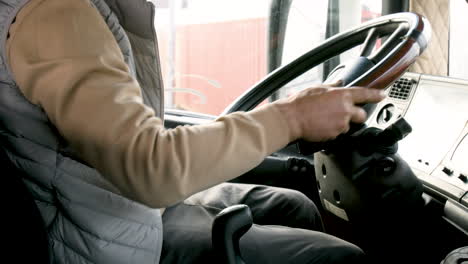 The-Camera-Focuses-On-The-Hands-Of-An-Older-Worker-On-Stick-Shift-And-Steering-Wheel-Of-A-Truck-1