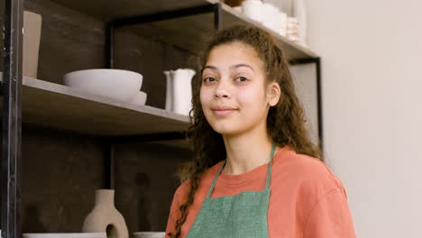Portrait-Of-A-Beautiful-Young-Female-Clerk-Smiling-And-Looking-At-The-Camera-While-Working-In-The-Pottery-Shop