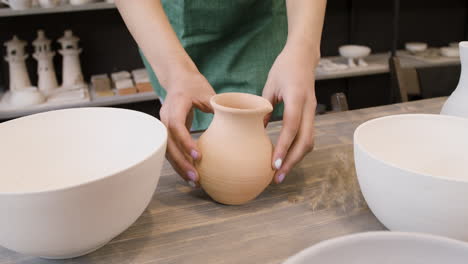 Close-Up-Of-An-Unrecognizable-Woman-Putting-A-Ceramic-Jug-On-A-Table-In-The-Pottery-Shop
