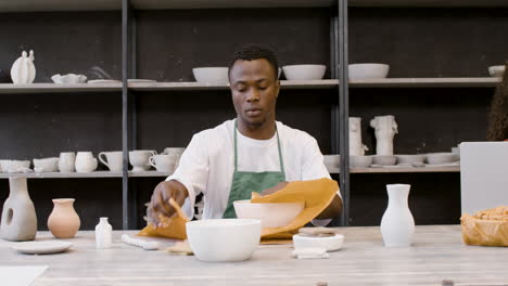 Young-Man-Packaging-Handicraft-Ceramics-With-Paper-In-The-Pottery-Shop