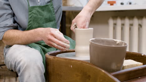 Nahaufnahme-Der-Hände-Eines-Angestellten,-Der-Keramikstücke-Auf-Einer-Töpferscheibe-In-Einer-Werkstatt-Modelliert