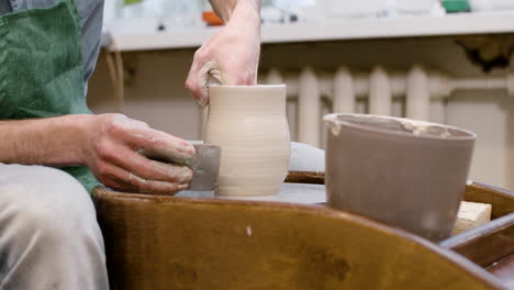 Hände-Eines-Angestellten,-Der-In-Einer-Werkstatt-Ein-Keramikstück-Auf-Einer-Töpferscheibe-Modelliert