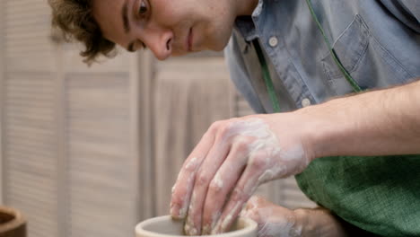 Close-Up-View-Of-Clerk-Modeling-Ceramic-Piece-On-A-Potter-Wheel-In-A-Workshop
