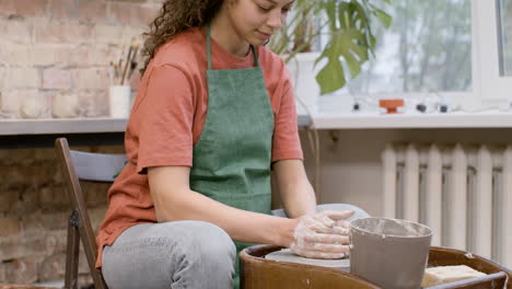 Angestellte-Frau,-Die-Keramikstück-Auf-Einer-Töpferscheibe-In-Einer-Werkstatt-Modelliert
