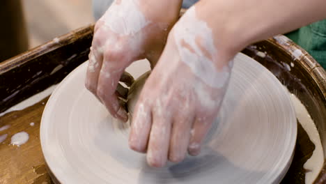 Nahaufnahme-Der-Hände-Eines-Angestellten,-Der-In-Einer-Werkstatt-Ein-Keramikstück-Auf-Einer-Töpferscheibe-Modelliert-1