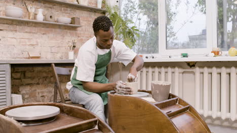 Amerikanischer-Angestellter,-Der-In-Einer-Werkstatt-Keramikstücke-Auf-Einer-Töpferscheibe-Modelliert