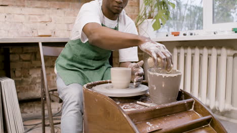 Amerikanischer-Angestellter,-Der-In-Einer-Werkstatt-Ein-Keramikstück-Auf-Einer-Töpferscheibe-Modelliert-1