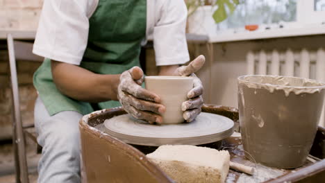 Bottom-View-Of-American-Clerk-Man-Modeling-Ceramic-Piece-On-A-Potter-Wheel-In-A-Workshop