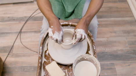 Top-View-Of-American-Clerk-Man-Modeling-Ceramic-Piece-On-A-Potter-Wheel-In-A-Workshop
