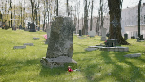Tombstone-With-A-Red-Rose-And-A-Grave-Candle-On-The-Grass-In-A-Graveyard-On-A-Sunny-Day-1