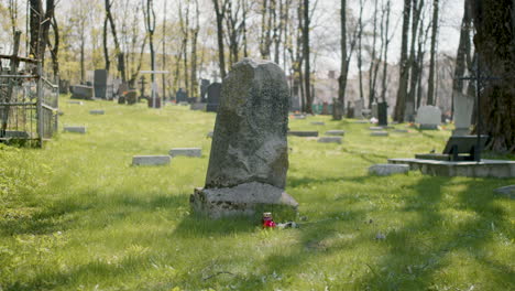 Tombstone-With-A-Red-Rose-And-A-Grave-Candle-On-The-Grass-In-A-Graveyard-On-A-Sunny-Day-2