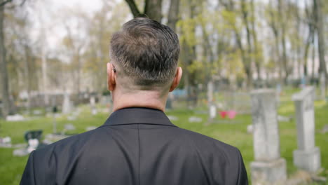 Back-View-Of-A-Man-In-Black-Suit-Walking-In-A-Graveyard
