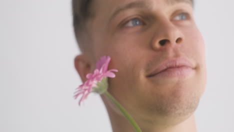 Close-Up-Of-Young-Man-Smiling-And-Holding-A-Flower