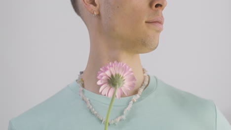 Handsome-Man-With-Green-T-Shirt-And-Necklace-Holding-Flower