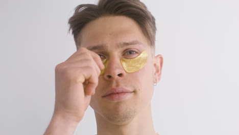 Young-Man-Using-And-Removing-Golden-Patch-For-The-Bags-Under-The-Eyes