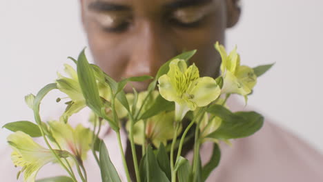 Close-Up-View-Of-Man-Smelling-Flowers-And-Looking-At-Front