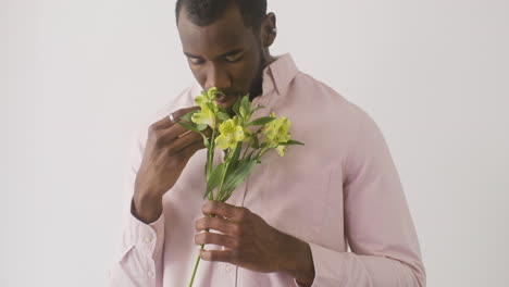 Young-Man-Touching-And-Smelling-Flowers