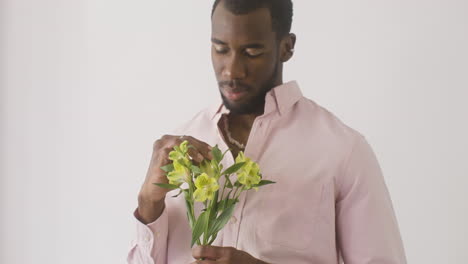 Handsome-Guy-Smelling-And-Touching-The-Flowers-On-His-Hand