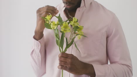 Hombre-Sosteniendo-Y-Tocando-Flores