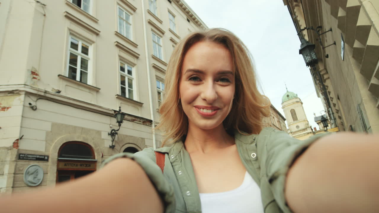 Premium ストック動画 - 町のカメラに笑顔と笑い声の陽気な美しい金髪の女性のハメ撮り