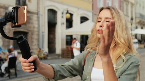 Fröhliche-Reisebloggerin-Erzählt-Etwas,-Während-Sie-Mit-Einem-Selfie-Stick-In-Der-Stadt-Ein-Video-Auf-Dem-Smartphone-Aufnimmt-1