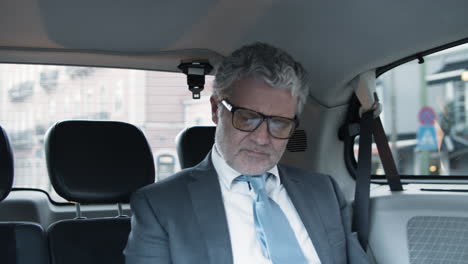 Senior-Bearded-Businessman-Sitting-In-Backseat-Of-Moving-Car