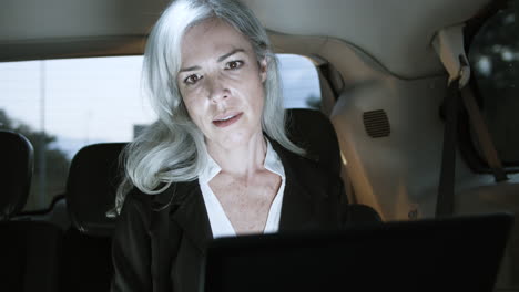 Businesswoman-Using-Laptop-In-Car