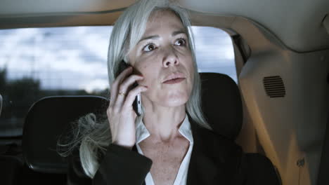 Mujer-Hablando-Por-Teléfono-Inteligente-Y-Usando-Una-Computadora-Portátil-Dentro-Del-Auto