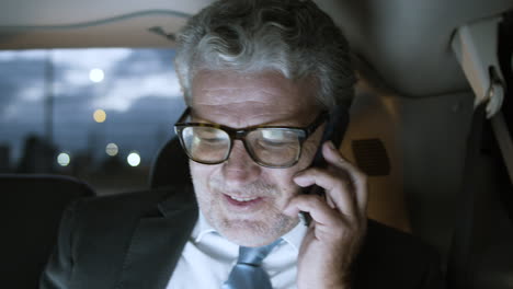Cheerful-Senior-Businessman-In-Car-Talking-On-Phone