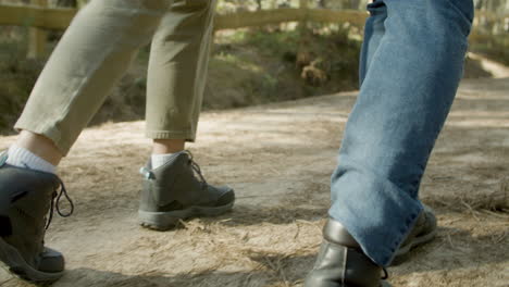 Closeup-Of-Young-Couple-Walking-Along-Dirt-Path-In-National-Park