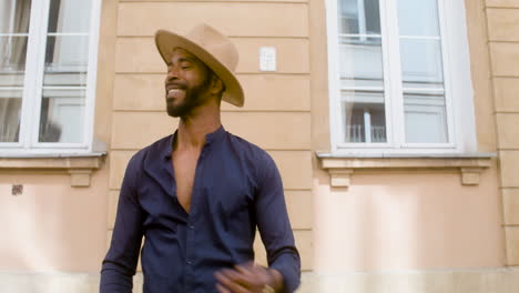 Smiling-Afro-Caribbean-Man-With-Panama-Hat-Dancing-Salsa-Alone-In-Street