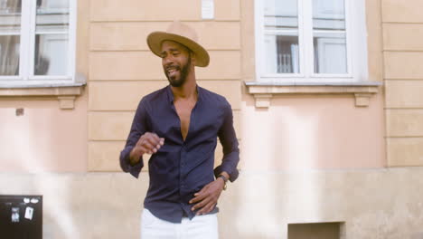 Smiling-Afro-Caribbean-Man-With-Panama-Hat-Dancing-Salsa-Alone-In-Street-2