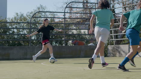 Active-Teenage-Girls-Playing-Football-Outdoors-And-One-Girl-Scores